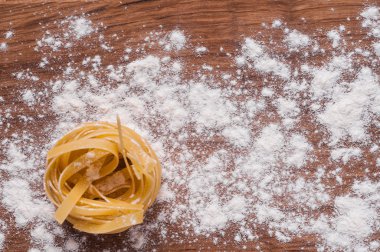 un kahverengi ahşap masa üzerinde ham tagliatelle