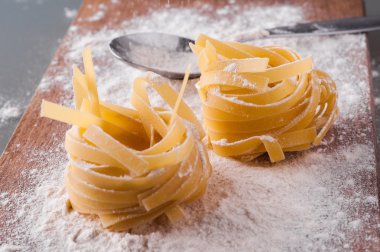 un kahverengi ahşap masa üzerinde ham tagliatelle