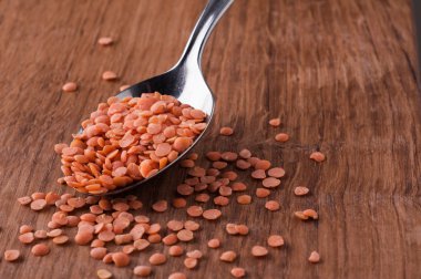 metal kaşık kahverengi ahşap masa üzerinde kırmızı mercimek