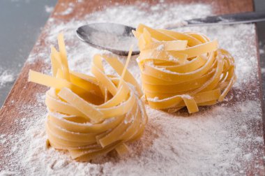 un kahverengi ahşap masa üzerinde ham tagliatelle