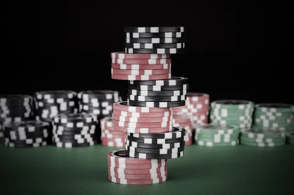 Zwarte, rode en groene casino chips op tafel — Stockfoto