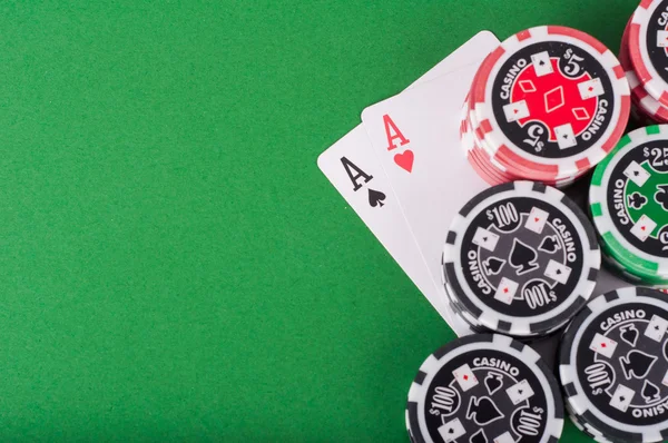 Paar azen, rode en zwarte cassino chips op groene tafel — Stockfoto