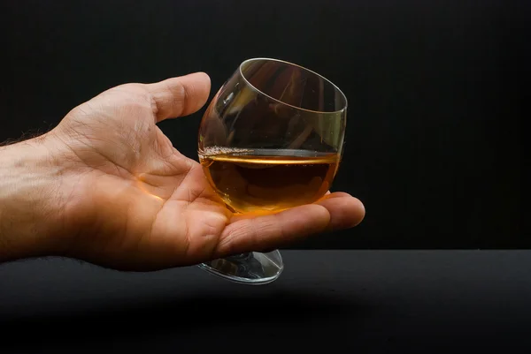 Cognac glas in menselijke hand — Stockfoto