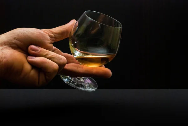 Cognac glas in menselijke hand — Stockfoto