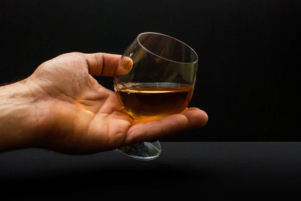 Cognac glas in menselijke hand — Stockfoto