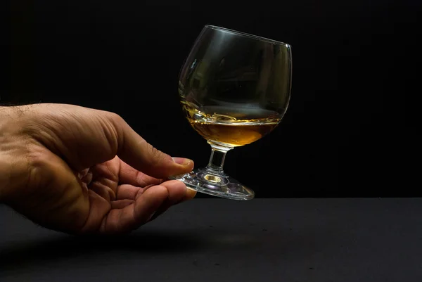 Cognac glas i mänsklig hand — Stockfoto