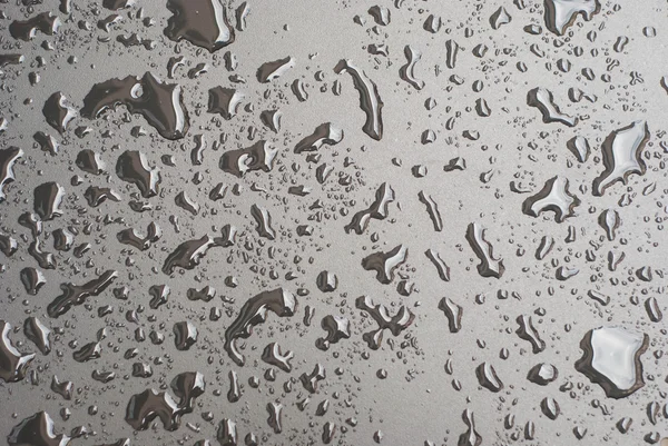 Water drops on black surface — Stock Photo, Image