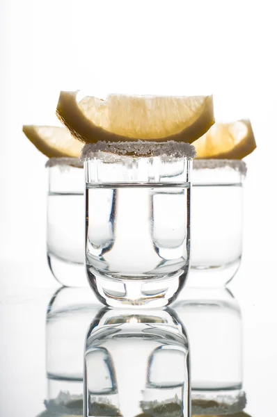 Три рюмки водки с лаймом — стоковое фото