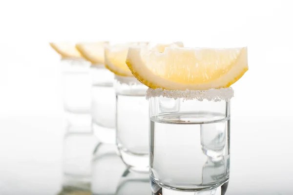 Four shots of vodka with lemon — Stock Photo, Image