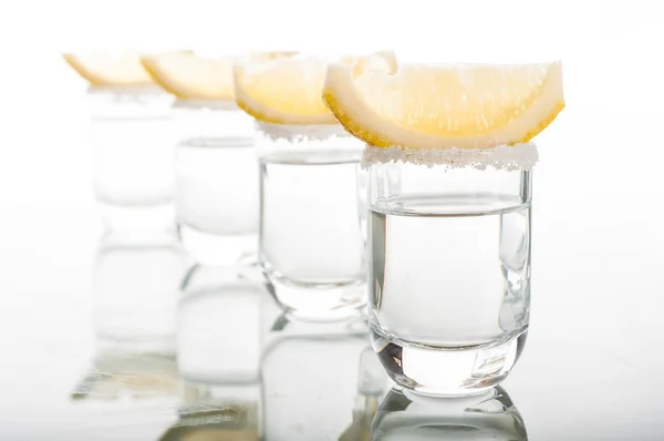 Four shots of vodka with lemon — Stock Photo, Image