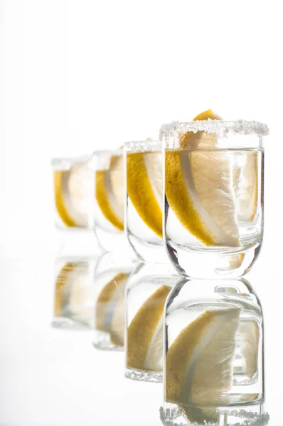 Vier Schuss Wodka mit Zitrone — Stockfoto