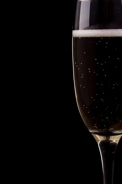 Un bicchiere di champagne su sfondo nero — Foto Stock