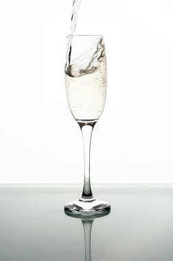 Beyaz arka planda şampanyayı cama dökmek