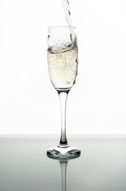 Beyaz arka planda şampanyayı cama dökmek