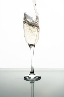 Beyaz arka planda şampanyayı cama dökmek
