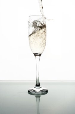 Beyaz arka planda şampanyayı cama dökmek