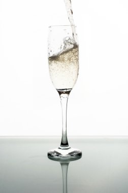 Beyaz arka planda şampanyayı cama dökmek