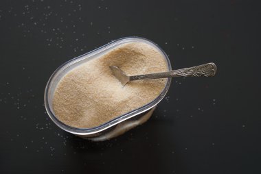 İrmik koyu ahşap masa üzerinde plastik kutu