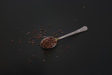 üzerinde koyu ahşap masa üzerinde metal kaşık keten tohumu