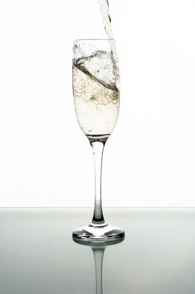 Pouring champagne into glass on white background — Stock Photo, Image