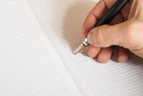 Mänsklig hand hålla pennan och skriva något i anteckningsboken — Stockfoto