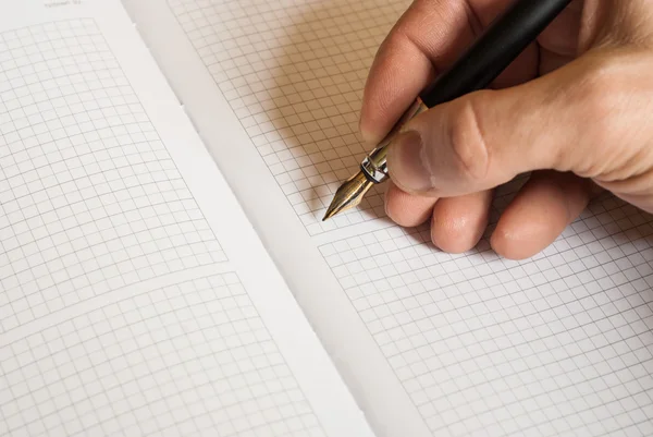 Mänsklig hand hålla pennan och skriva något i anteckningsboken — Stockfoto