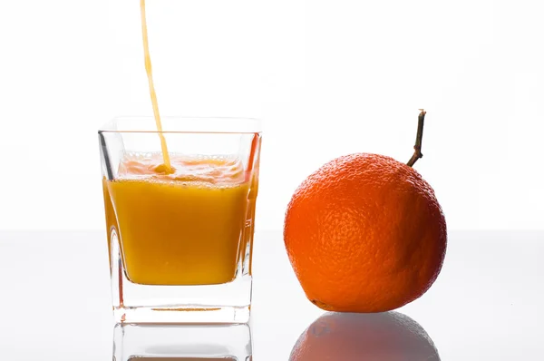 Jugo de naranja vertiendo en el vaso —  Fotos de Stock