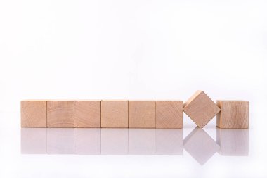 Sekiz tahta küp, kelimeleri ve mesajları kopyalamak için boş alanı olan bloklar beyaz yansıtıcı arka planda yatıyor. İş fikri.