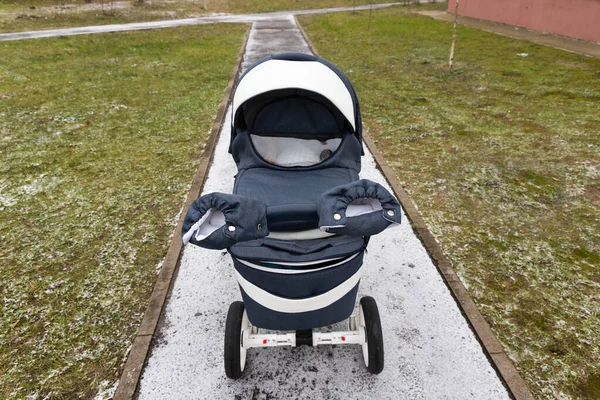 Kereta bayi di trotoar bersalju. Setiap hari berjalan di udara segar. Menghabiskan waktu dengan bayi Anda pada hari musim dingin bersalju putih. — Stok Foto
