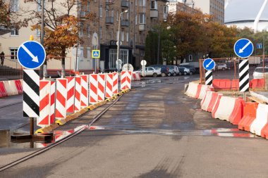 Şehir caddesi boyunca turuncu uyarı işaretli inşaat bölgesi.