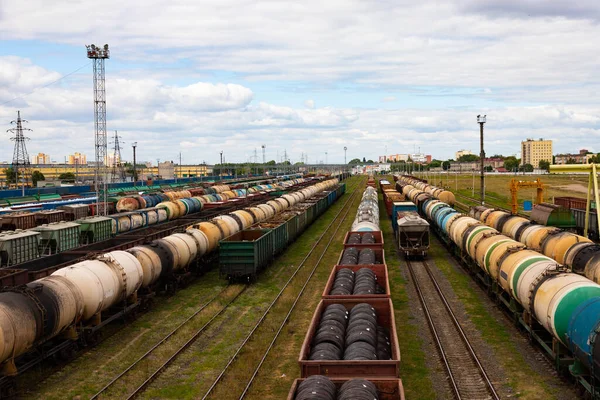 Tanks with fuel, wagons with cargo at a freight railway station. Logistics and transportation concept.