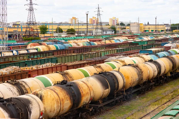 Tanks with fuel, wagons with cargo at a freight railway station. Logistics and transportation concept.