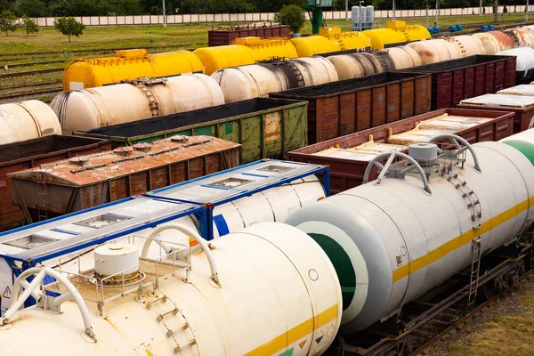 Tanks with fuel, wagons with cargo at a freight railway station. Logistics and transportation concept.