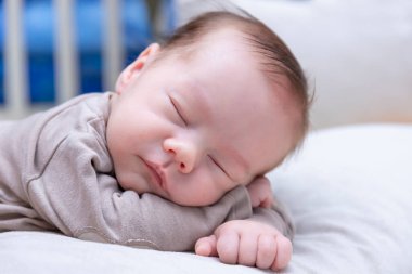 Yeni doğmuş erkek bebek yatakta uyuyor, yakın plan..