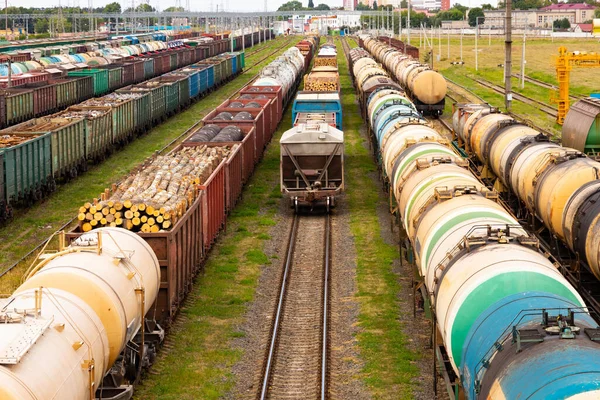 Tanks with fuel, wagons with cargo at a freight railway station. Logistics and transportation concept.