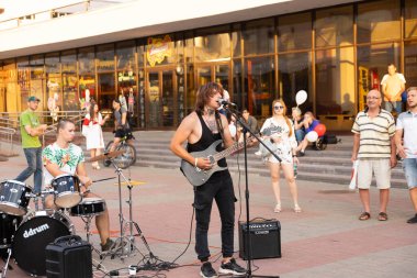 MINSK, BELARUS - 23 AĞUSTOS 2020: İzleyicilerle çevrili bir şehir caddesinde bir rock grubunun konseri. Seçici odak