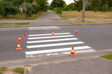 Trafik işaretleri ile işaretleme yeni bir renkli yaya geçidi. Yol işaretleriyle trafiğin kısıtlanması. Yol işaretlemelerini çizmek ve güncellemek için bir makine. Güvenlik ve trafik kuralları