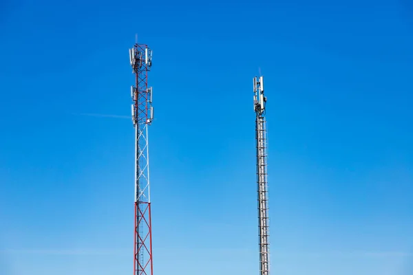 Cellular Base Station or Base Transceiver Station. Telecommunication tower. Wireless Communication Antenna Transmitter. 3G, 4G and 5G Cell Site with blue and cloudy sky.