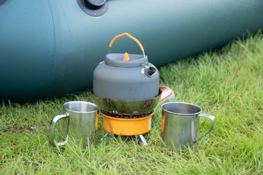 Gaz ocağındaki turist çaydanlığı. Saha koşullarında yemek pişirmek. Turist gaz ocağı kullanarak.