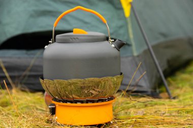 Gaz ocağındaki turist çaydanlığı. Saha koşullarında yemek pişirmek. Turist gaz ocağı kullanarak.