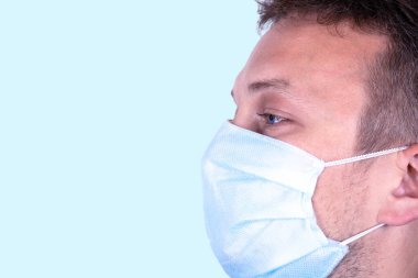 Beyaz arka planda izole edilmiş maskeli genç doktorun portresi.