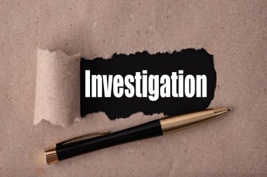 Yırtık bir kağıt ve metal bir kalemle yazılmış INVESTIGATION metni. İş stratejisi kavramları.