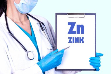 Zn ZINK metni tıbbi giysiler ve tek kullanımlık eldivenler giyen bir doktor tarafından tutulan bir tablete yazılmıştır. Tıbbi konsept.