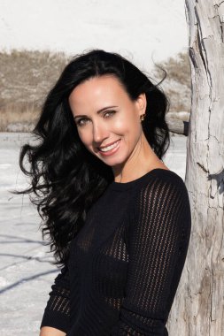 Koyu renk saçlı güzel bir kadının portresi, yaz günbatımının arka planında bir kız ve yeşil bir park.