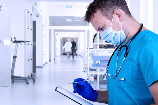 Tıbbi giysili genç doktor tıbbi geçmişi inceliyor ve kalemle not alıyor. Tıbbi konsept