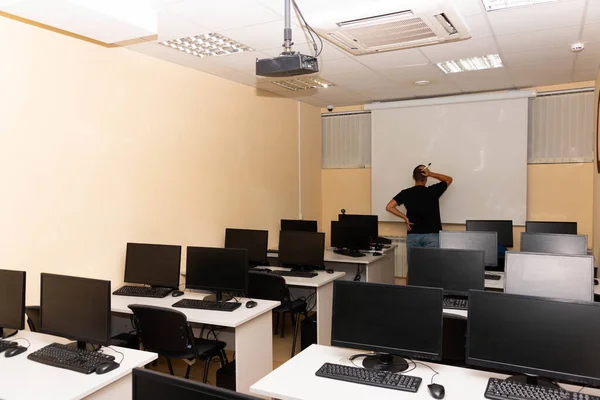 Empty classroom, school auditorium with chalkboard and computers on the desk. Education concept.