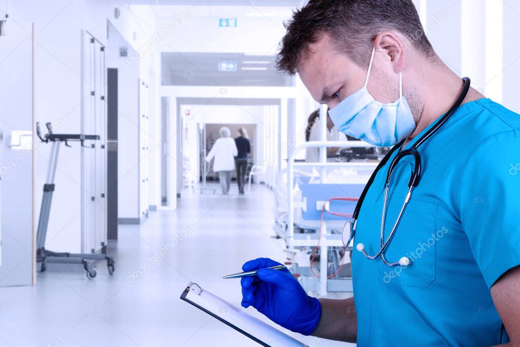 Young doctor in medical clothes examines the medical history and takes notes with a pen. Medical concept