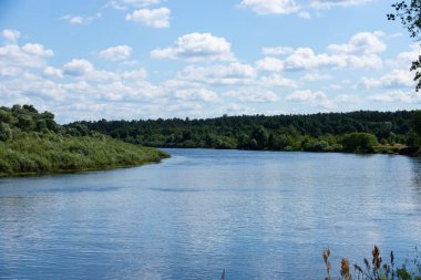 Parlak mavi gökyüzü ve bulutlarıyla yaz nehri