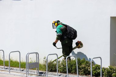 Bir adam şehirde çim biçiyor..