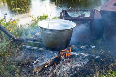 Kamp gezisinde açık bir tencerede yemek pişirmek..